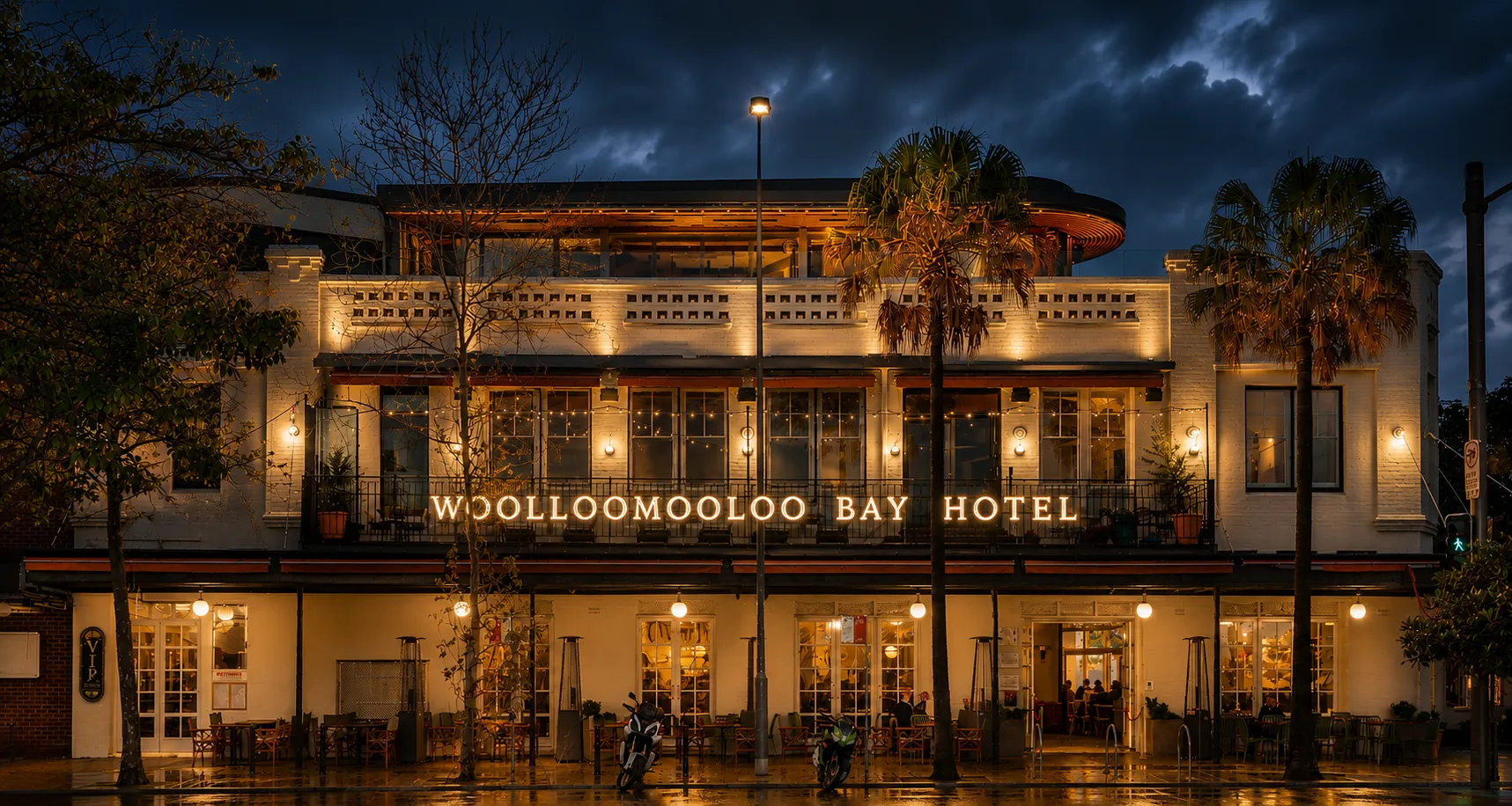 Historic Mollongool Bay Hotel illuminated at night under a dramatic sky.