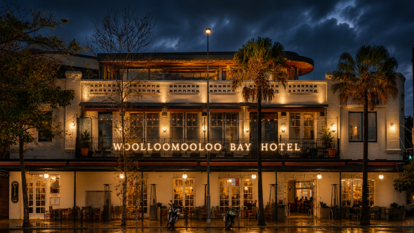 Historic Mollongool Bay Hotel illuminated at night under a dramatic sky.